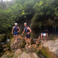 A calm and peaceful section of the Cetina River glowing with warm sunset colors, as rafters gently float downstream. eaceful stretch of Cetina River during rafting trip