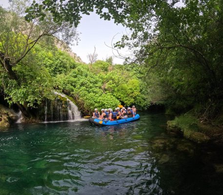 Happy group of rafters sharing an exciting adventure together on the Cetina River near Split. Group of rafters enjoying their ride on the Cetina River