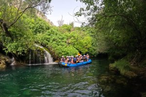 Happy group of rafters sharing an exciting adventure together on the Cetina River near Split. Group of rafters enjoying their ride on the Cetina River
