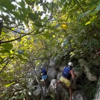 Vesela ekipa u čamcu spušta se niz brze dijelove rijeke, okruženi zelenilom Climbing on a rocks near Omiš