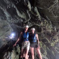 Couple exploring cave and posing for a picture