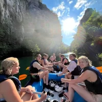 group of rafters goes down a small cascade with splashing water all around. Morning rafting with a happy party on a Cetina in Dalmatia