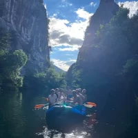 Participants float calmly through a peaceful section of the river, surrounded by cliffs and forest. Tourists rafting in the untouched nature of the Cetina River